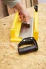 A person's hand is shown adjusting a saw blade within a yellow miter box, which is placed on a wooden surface. Náhľad obrázku produktu