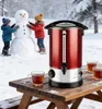 Children building a snowman in the snow, with a hot drink dispenser and cups on a wooden table in the foreground. Náhled obrázku produktu