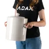 A person is holding a large beige crock with a lid. Podgląd zdjęcia produktu