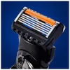 Close-up of a razor head with multiple blades and an orange lubrication strip. Produktbild-Vorschau