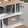 A close-up view of a white cabinet with wooden accents, showing shelves filled with books and a storage box. Náhled obrázku produktu