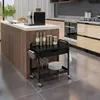 A kitchen scene with a coffee machine on an island and a black rolling cart with kitchenware. Produktbild-Vorschau