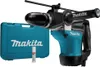 A teal and black rotary hammer drill with its case and a tube of grease, displayed on a white background. Produktbild-Vorschau