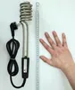 A portable immersion heater with a power cord and plug, placed next to a measuring tape and a person's hand for scale. Produktbild-Vorschau