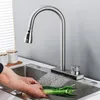 A person is washing green onions in a kitchen sink under a faucet. Podgląd zdjęcia produktu