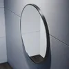 A round black mirror with an aluminum frame hangs on a tiled wall. Náhľad obrázku produktu