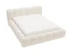 A cream-colored upholstered bed frame with a mattress on a white background. Produktbild-Vorschau
