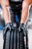 A person wearing black gloves is holding a tire. Voir les images du produit