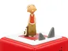 A figurine of a boy with a backpack stands on a red and white base, with two gray shark fins protruding from the base. Produktbild-Vorschau
