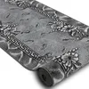 A rolled-up rug with a floral and leaf pattern. Produktbild-Vorschau