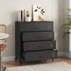 A black metal dresser with four drawers is shown in a room setting, with a chair and table to the left and a plant to the right. Produktbild-Vorschau