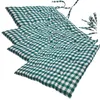 A stack of green and white checkered seat cushions. Produktbild-Vorschau