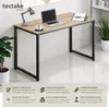 A modern desk with a laptop, lamp, and coffee cup on it, set against a neutral background with decorative plants. Produktbild-Vorschau