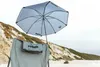 A beach scene with a chair and umbrella. Produktbild-Vorschau