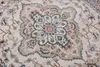 A close-up view of a traditional rug with an intricate central medallion pattern. Produktbild-Vorschau