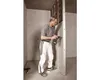 A man is installing a wall panel in a room under construction. Produktbild-Vorschau