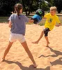 Two children are playing with boxing gloves in the sand. Produktbild-Vorschau