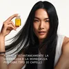 A woman holds a small bottle of Olaplex No. 7 Bonding Oil, with her hair flowing around her. Voir les images du produit