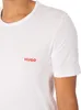 Close-up of a person wearing a white t-shirt with a red logo. Produktbild-Vorschau