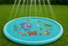 A children's inflatable splash pad with water spraying from the center, set on a green lawn. Anteprima dell’immagine prodotto