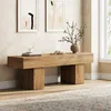 A wooden bench in a room with artwork on the wall and a rug on the floor. Voir les images du produit