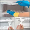 A collage of images showing a person wearing blue and yellow gloves cleaning frost from a refrigerator with a white scraper. Produktbild-Vorschau