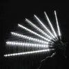 A set of white LED meteor shower lights arranged in a fan shape on a dark, textured surface. Produktbild-Vorschau