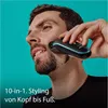 A man is using a grooming device on his beard against a teal background. Produktbild-Vorschau