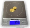 A digital scale with three gold coins on its platform. Produktbild-Vorschau