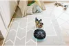 A robot vacuum cleaner is shown navigating a child's play area, with virtual lines indicating its cleaning path. Produktbild-Vorschau