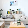 A living room scene with a sofa, coffee table, and shelves. Produktbild-Vorschau