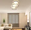 A modern living room with a sectional sofa, blinds on the window, and a unique ceiling light fixture. Produktbild-Vorschau