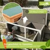 A child is interacting with a rabbit in a two-story hutch outdoors. The image highlights the hutch's features, including its waterproof roof and impregnated wood. Produktbild-Vorschau