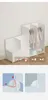 A white modular wardrobe system is shown, with some sections filled with clothes on hangers. There are also two smaller inset images illustrating assembly details. Voir les images du produit