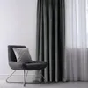 A dark gray armchair with a gray patterned pillow sits next to a dark gray velvet curtain and a sheer white curtain. Produktbild-Vorschau