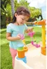 A young girl playing with a water table in a backyard. Náhľad obrázku produktu