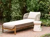 A chaise lounge and side table are set up on a brick patio surrounded by greenery. Podgląd zdjęcia produktu