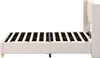 A side view of a beige upholstered bed frame with a slatted mattress support. Produktbild-Vorschau