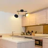 A modern kitchen with light wood cabinets and a countertop, featuring a black and wood ceiling light fixture with two adjustable spotlights. Voir les images du produit