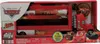 The image shows the retail packaging of a Disney Pixar Cars Mini Racer Transporter Mack toy. Produktbild-Vorschau