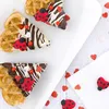 Three heart-shaped waffles decorated with chocolate, white icing, and ladybug candies, scattered with heart-shaped sprinkles. Anteprima dell’immagine prodotto