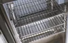Close-up view of the interior of a grill, showing multiple stainless steel racks. Produktbild-Vorschau