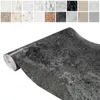 A roll of marble-effect wallpaper with a collage of different wallpaper samples above it. Produktbild-Vorschau