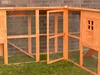 An outdoor view of a wooden chicken coop with an open door and wire mesh. Produktbild-Vorschau