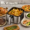 An air fryer filled with french fries, surrounded by various cooked dishes including a whole chicken, steak, pizza, salmon, broccoli, and asparagus, suggesting the versatility of the appliance. Anteprima dell’immagine prodotto