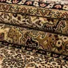 A close-up view of a folded oriental rug with intricate patterns. Produktbild-Vorschau