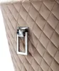 A close-up of a quilted beige chair with a silver handle. Náhled obrázku produktu