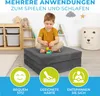 A young boy is playing with blocks on a folded mattress in a child's room. There are decorative clouds and a star on the wall, along with storage units and a laundry basket. Produktbild-Vorschau