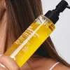 A person is holding a bottle of cleansing oil. Produktbild-Vorschau