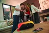 Four young people are singing into a microphone connected to a portable speaker with LED lights. Voir les images du produit